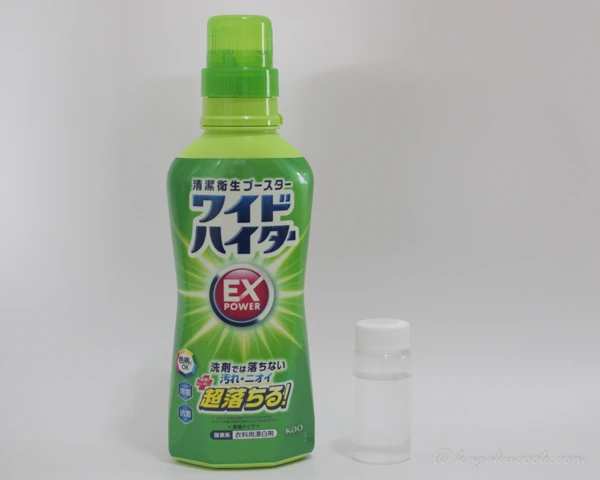 ワイドハイター EXパワーの容器と、ガラスのサンプル瓶に入れた粉末。